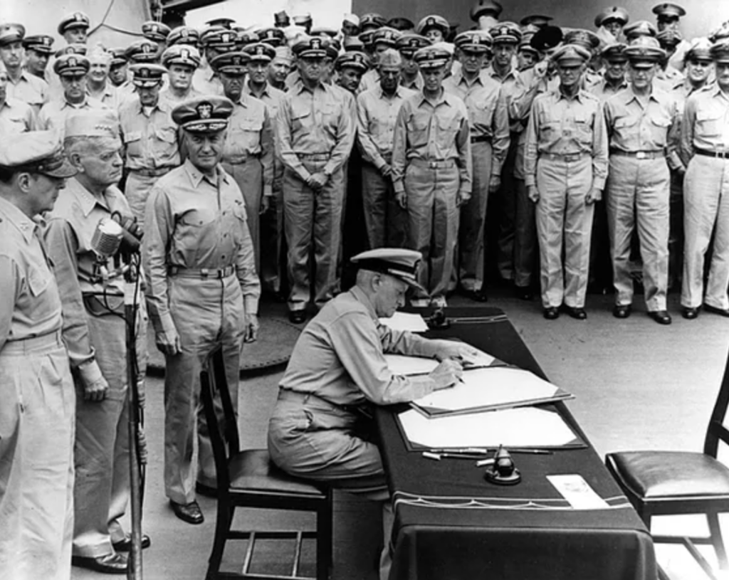 Fleet Admiral Chester W. Nimitz, USN, signs the Instrument of Surrender as United States Representative