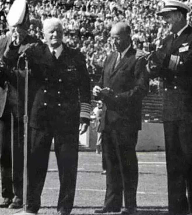 Fleet Admiral Nimitz acknowledges the cheers of football fans at the game between the University of California and the Naval Academy. 